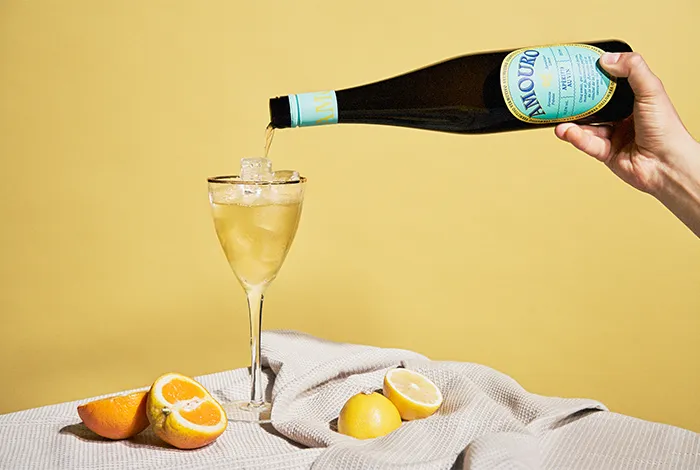 Eine nahaufnahme eines Amourini Cocktails, garniert mit einer Orangenzeste