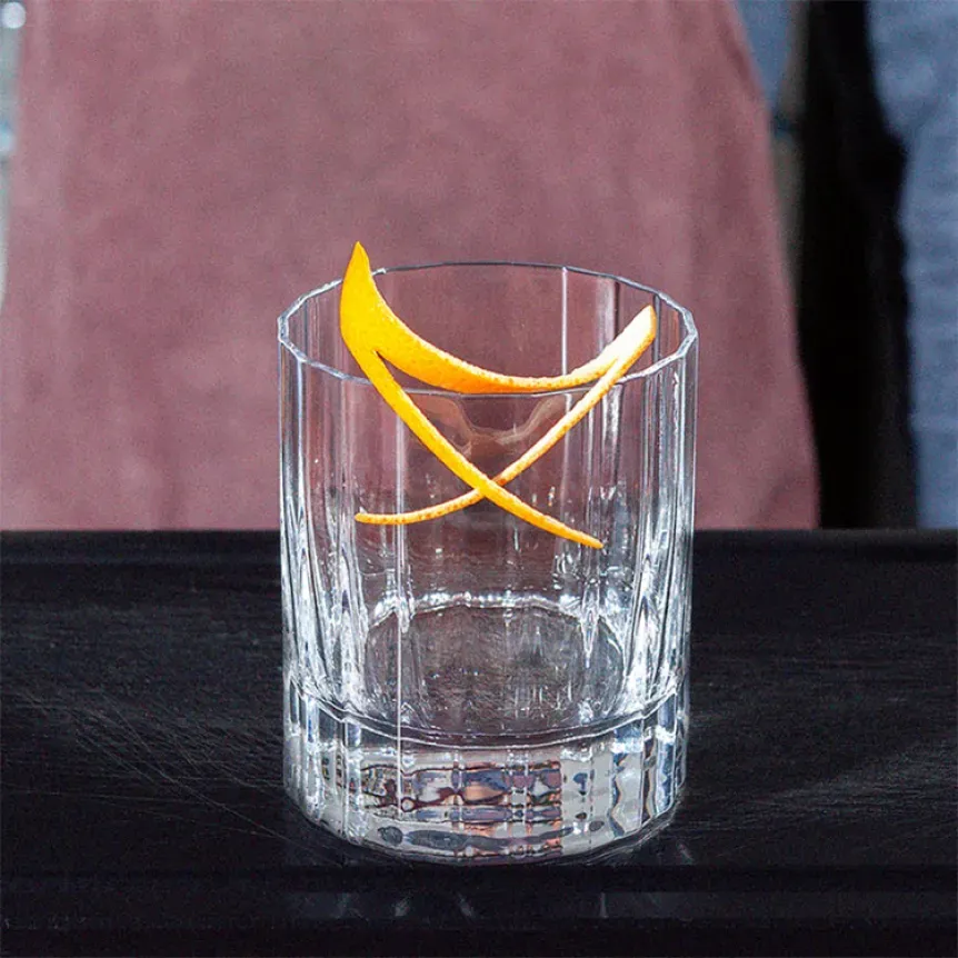 Eine Orangenzeste als elegante Garnitur für einen frisch zubereiteten Cosmopolitan.