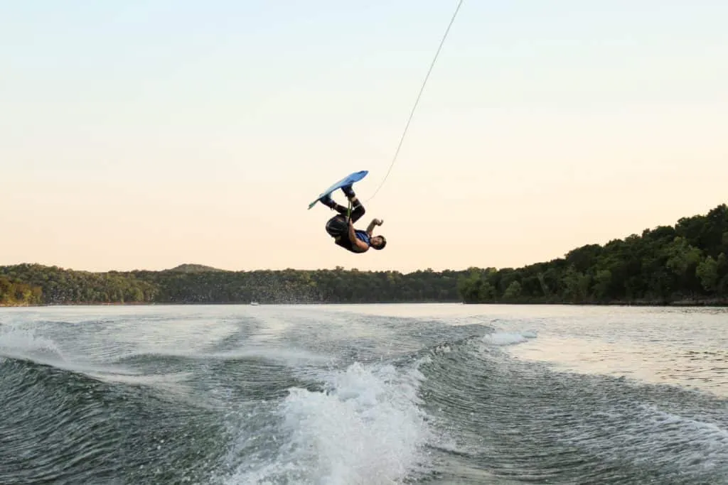 Eine Person fährt Wakeboard auf einem See bei Sonnenuntergang