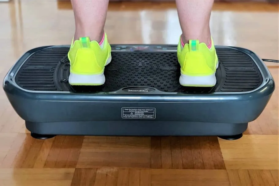 Eine Person steht auf einer Vibrationsplatte und trainiert