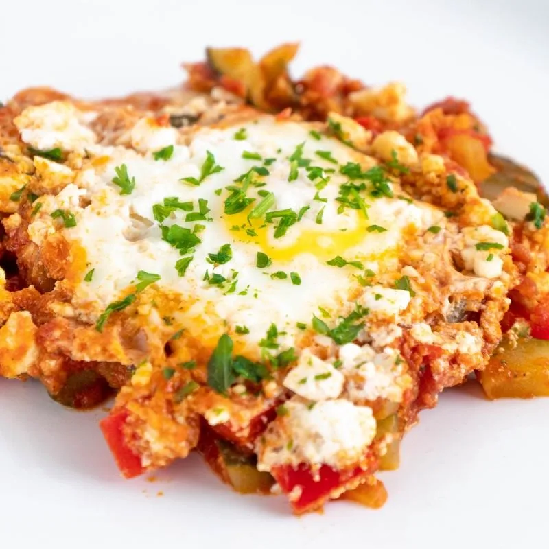 Eine Pfanne mit Keto Shakshuka, Eier pochiert in würziger Tomatensoße, ein wärmendes und sättigendes herzhaftes Frühstück.