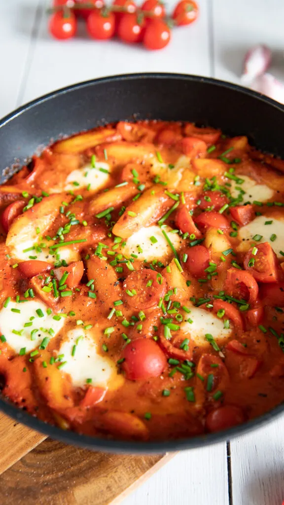 Eine Portion Schupfnudeln in cremiger Tomatensoße, garniert mit Schnittlauch