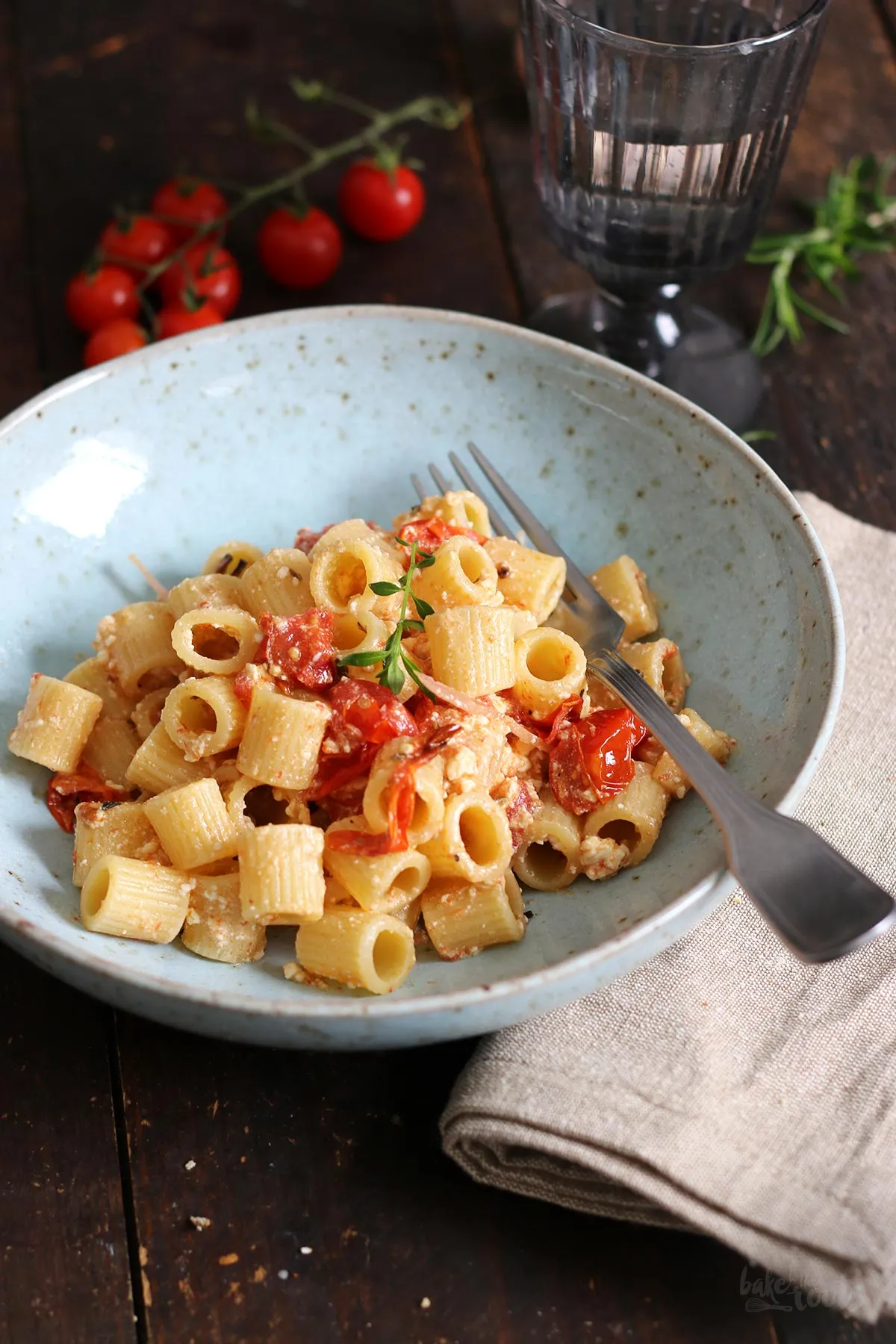 Eine Portion Tomaten-Feta-Pasta auf einem Teller, appetitlich angerichtet mit frischen Kräutern.