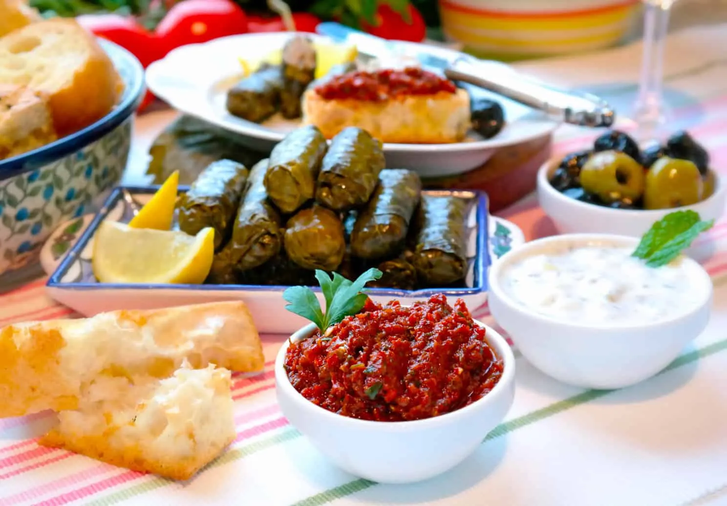 Eine reichhaltige Auswahl türkischer Vorspeisen, bekannt als Meze, appetitlich angerichtet auf einem Holztisch, darunter angemachte Oliven, Cremes und Gemüsegerichte.