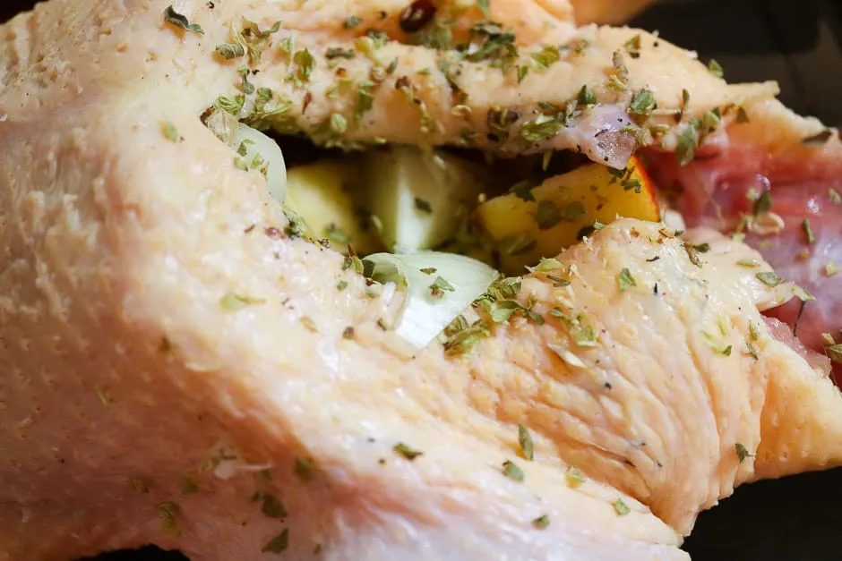 Eine rohe Gans, gefüllt mit Äpfeln und Zwiebeln, bereit für den Ofen.