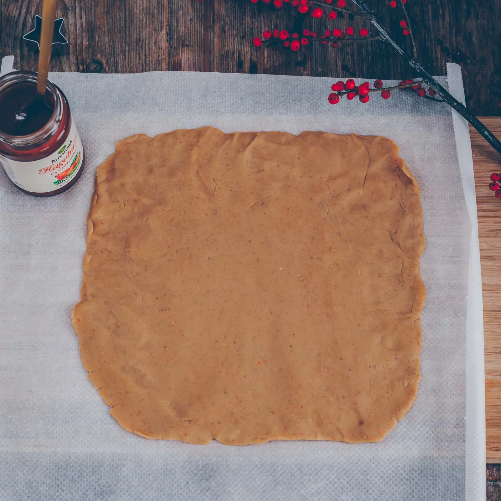 Eine Rolle rohen Teigs, gefüllt mit Hagebuttenkonfitüre, bereit zum Schneiden