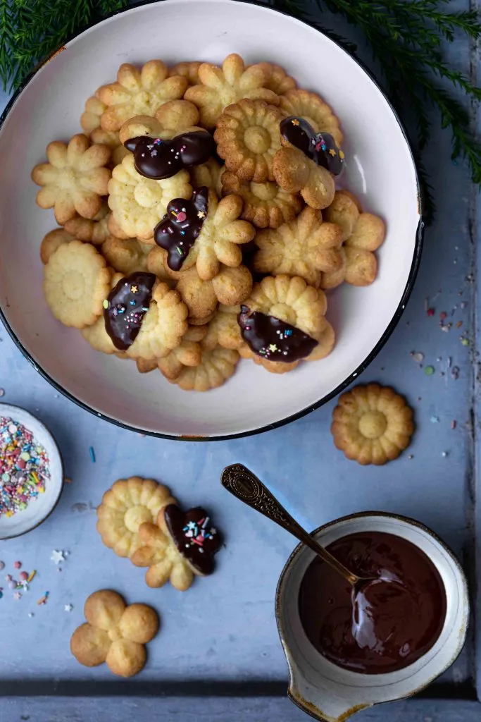 Eine Sammlung von zartem Butterspritzgebäck in verschiedenen Formen, golden gebacken und auf einem Teller arrangiert