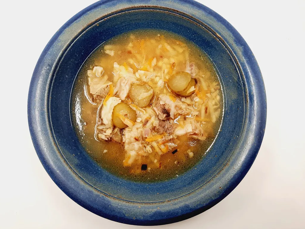 Eine Schale Rassolnyk, eine herzhafte ukrainische Fleischsuppe mit Graupen, sauren Gurken und frischen Kräutern.