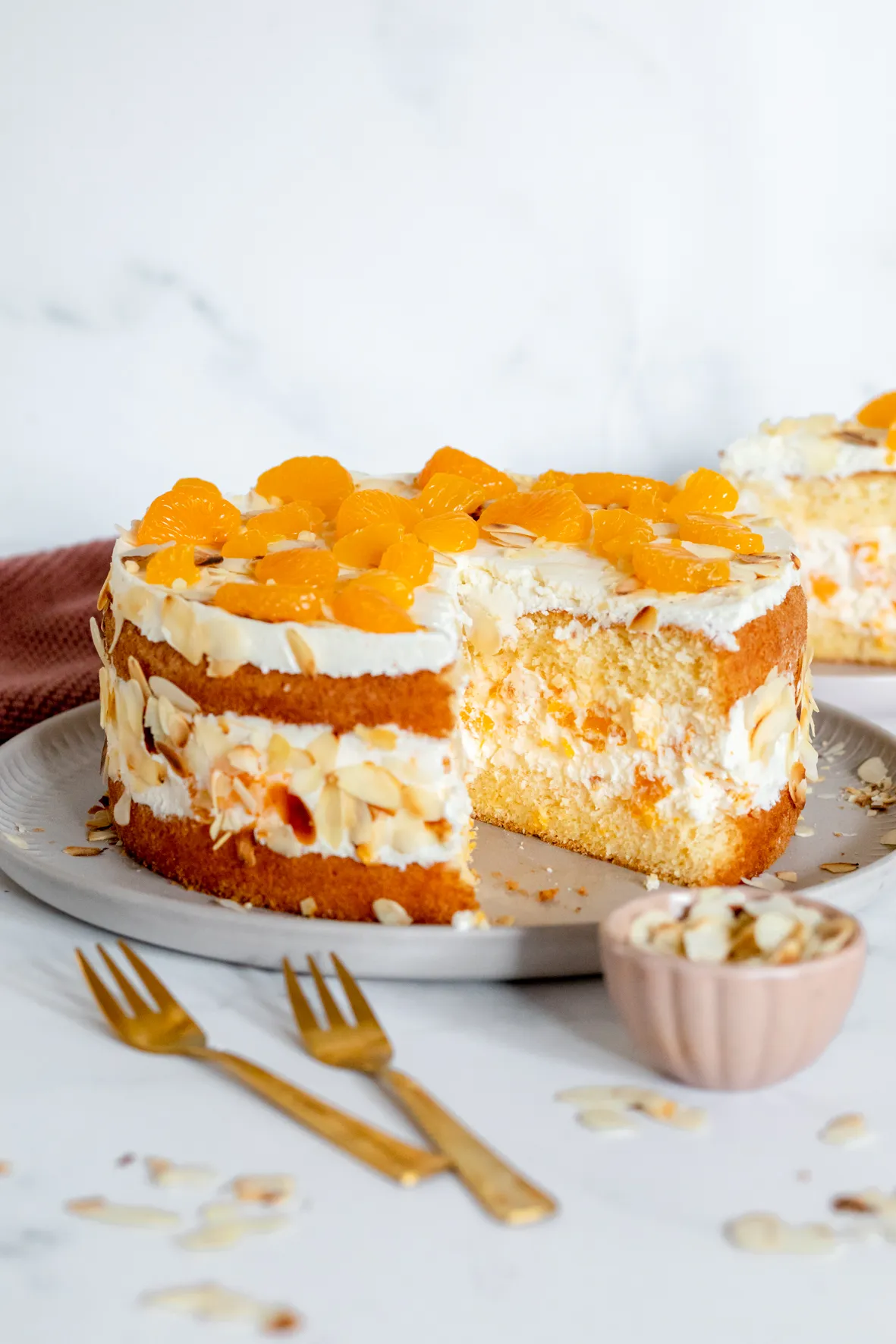 Eine Scheibe Mandarinen-Sahne-Torte auf einem Teller, perfekt geschichtet
