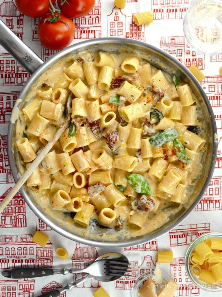 Eine Schüssel cremige Nudeln mit getrockneten Tomaten und frischem Basilikum