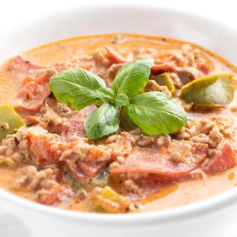 Eine Schüssel mit leckerer Pizzasuppe, die an Pizza erinnert.