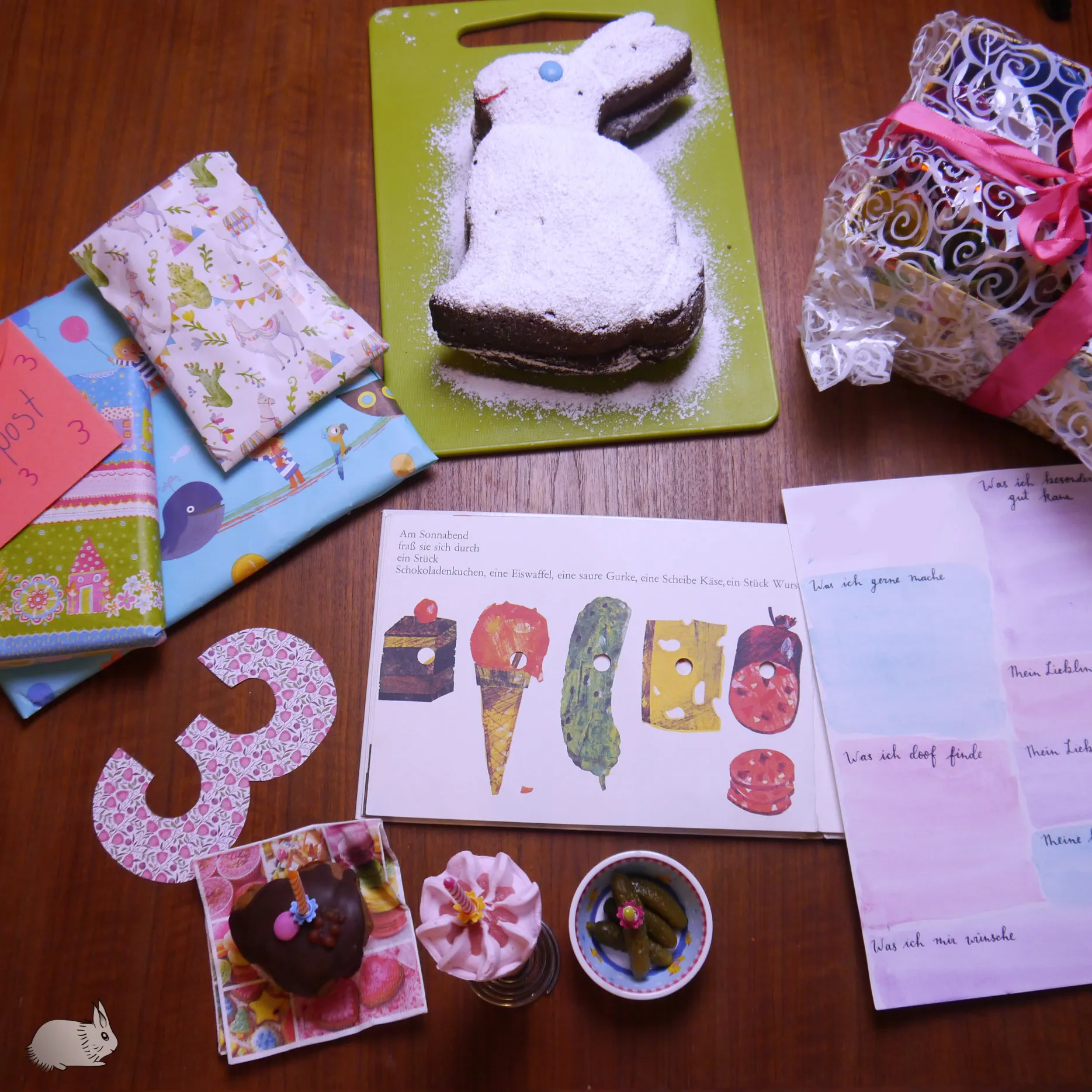 Eine Seite aus dem Buch &quot;Die kleine Raupe Nimmersatt&quot; mit verschiedenen Lebensmitteln.