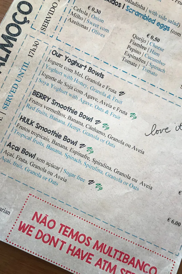 Eine Tasse Kaffee oder Tee auf einem Holztisch mit einer Pflanze im Hintergrund, in einer entspannten Umgebung