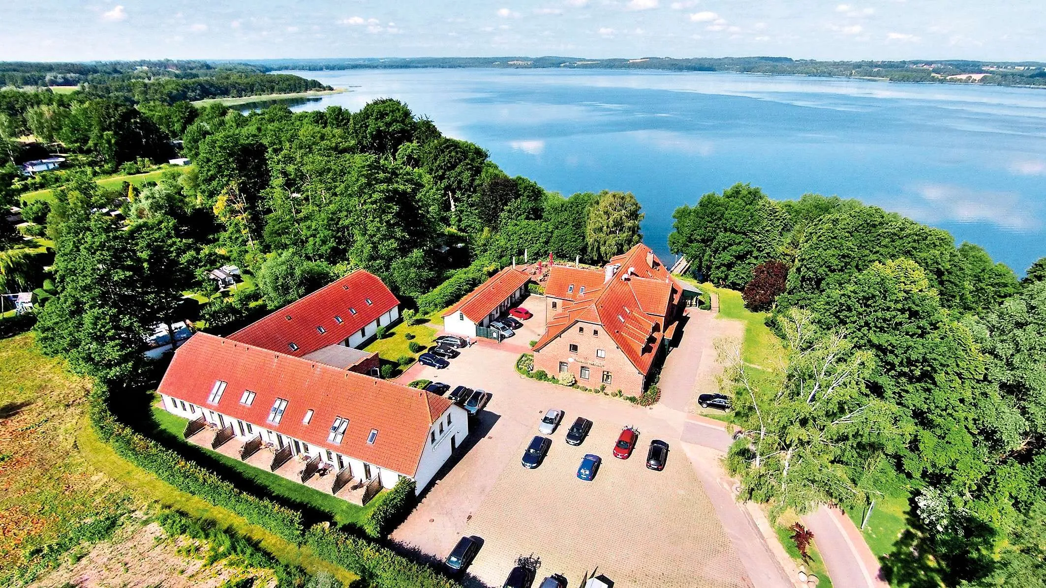Eine Übersicht der Gebäude des Seehotel Heidehof in Klein Nemerow, idyllisch am Wasser gelegen und hundefreundlich.
