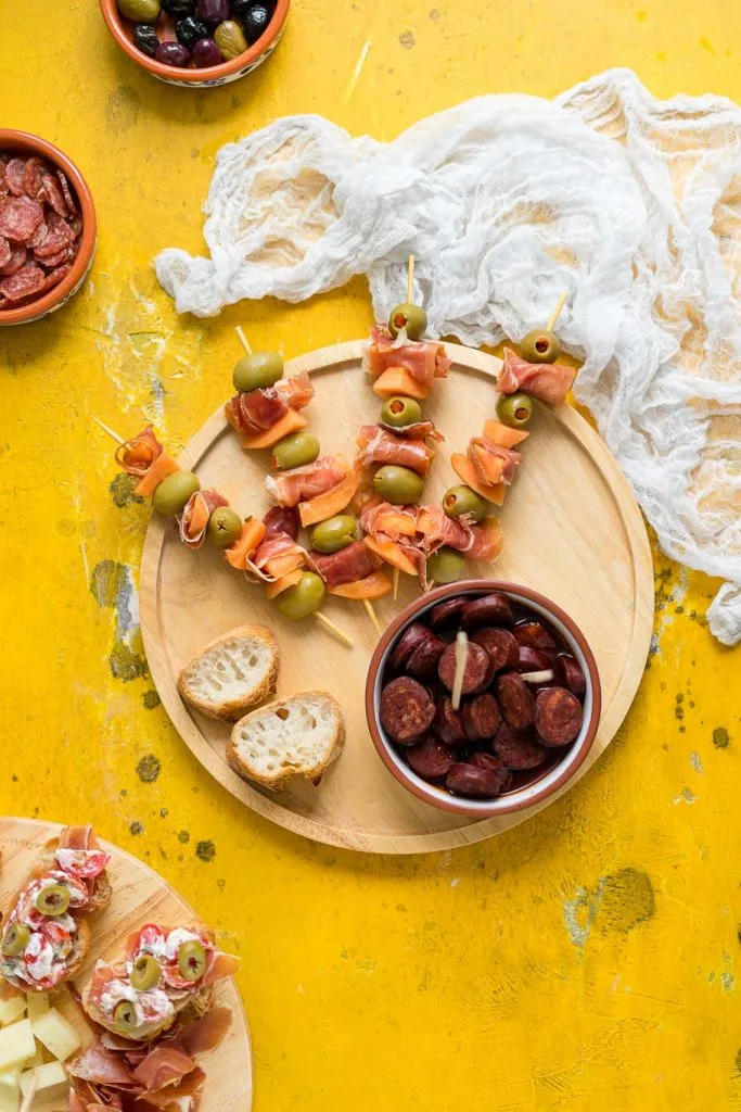 Eine wunderschön arrangierte spanische Tapas-Platte mit einer Vielzahl von Köstlichkeiten, die zum Teilen einladen.