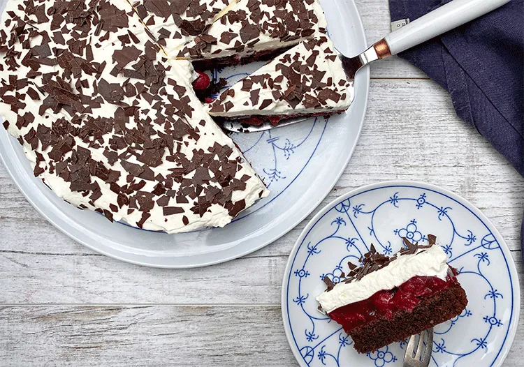 Einfache Kirsch-Sahne-Torte mit Schokoboden und Kirschfüllung im Anschnitt