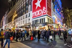 Einkaufsstraße in New York City mit Geschäften und Fußgängern, ein Beispiel für New York City Reisetipps zum Shoppen.