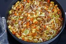 Eintopf mit Gemüsebrühe ablöschen und zum Köcheln bringen