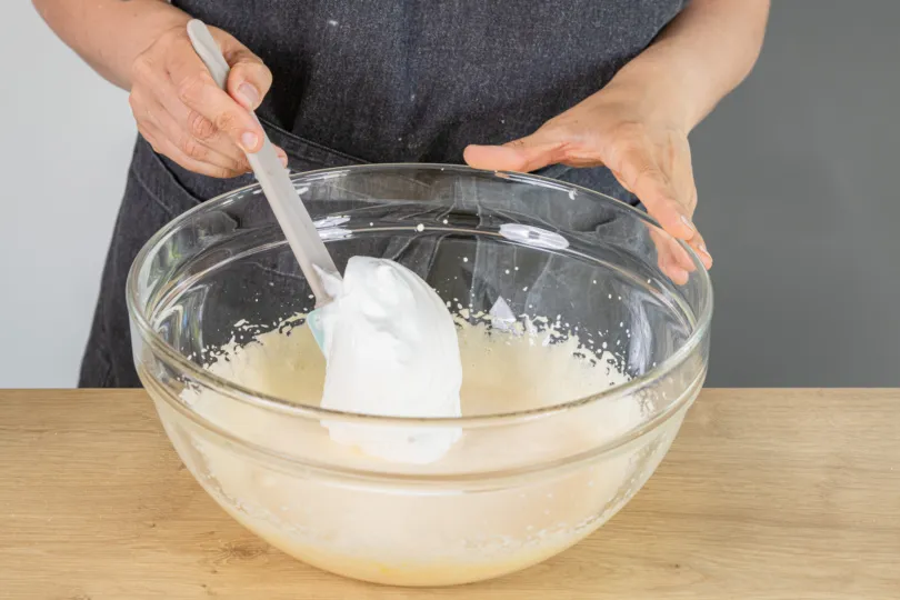 Eischnee wird unter die Eigelbmischung gehoben