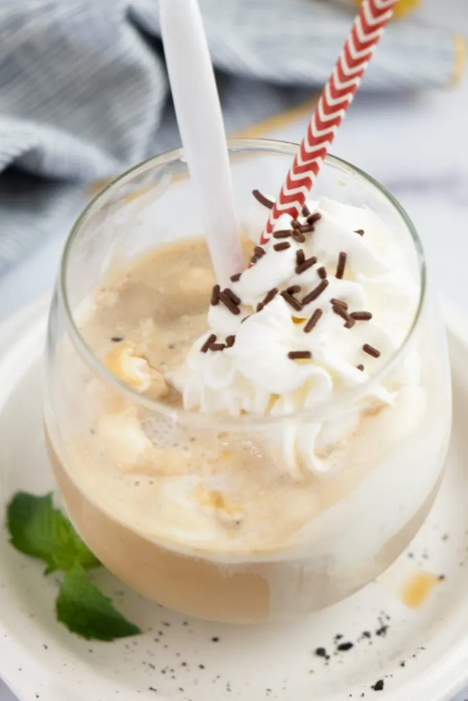 Eiskaffee mit langem Löffel und Strohhalm auf einem Tisch