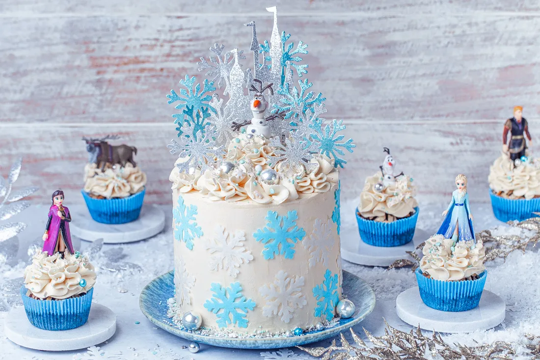 Elsa Torte mit blauer und weißer Creme, verziert mit Schneeflocken und Zuckerstreuseln