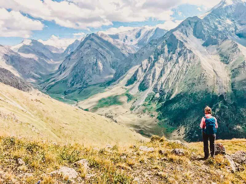 Endlose Steppenlandschaft mit majestätischen, schneebedeckten Bergen in Kirgistan im August