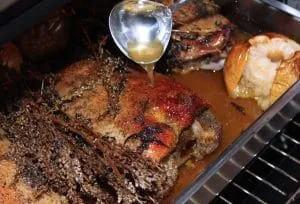 Entfernen von überschüssigem Gänsefett und Apfelsaftmischung aus dem Bräter