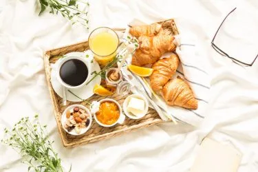 Entspanntes Frühstück im Bett mit frisch gelieferten Brötchen und Kaffee