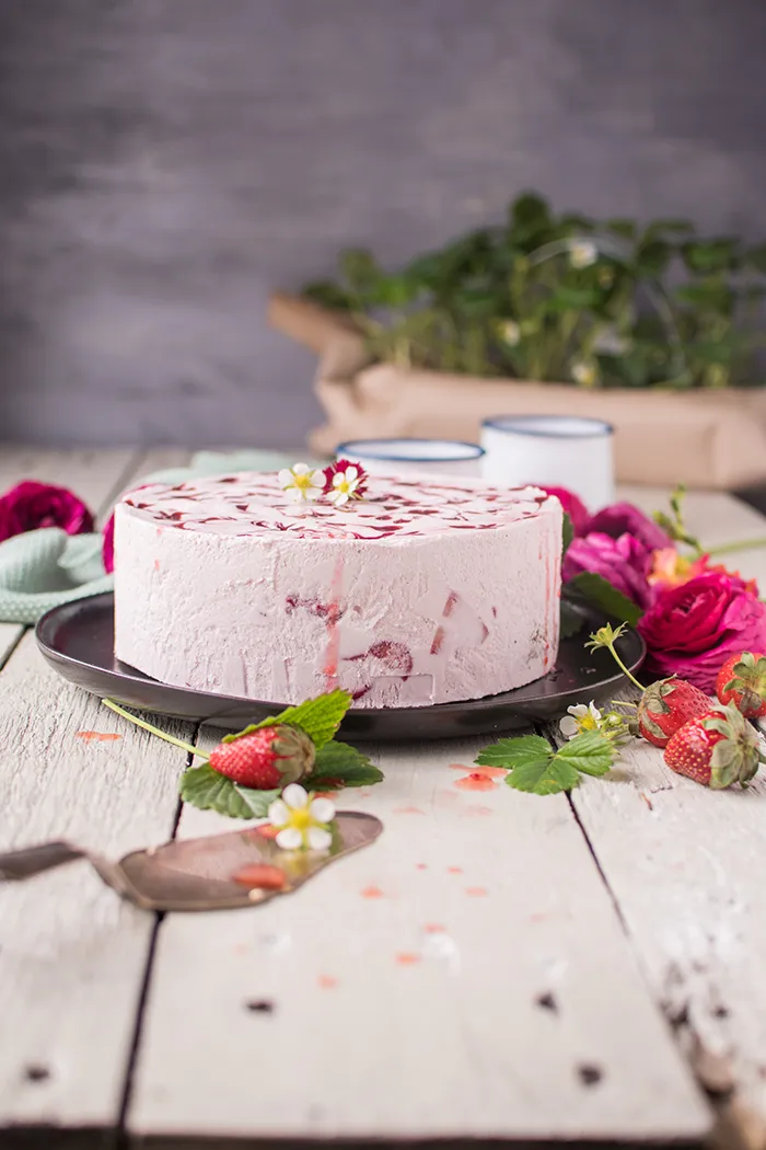 Erdbeerpflanzen mit kleinen, heranreifenden Früchten im Garten