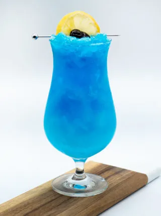 Erfrischender blauer Drink mit Zitronenscheibe und Kirsche