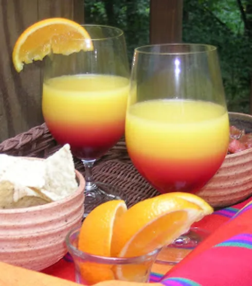 Exotischer Arizona Sunset Cocktail mit Kaktusfeigensirup und Orangensaft, garniert mit einer Orangenscheibe.