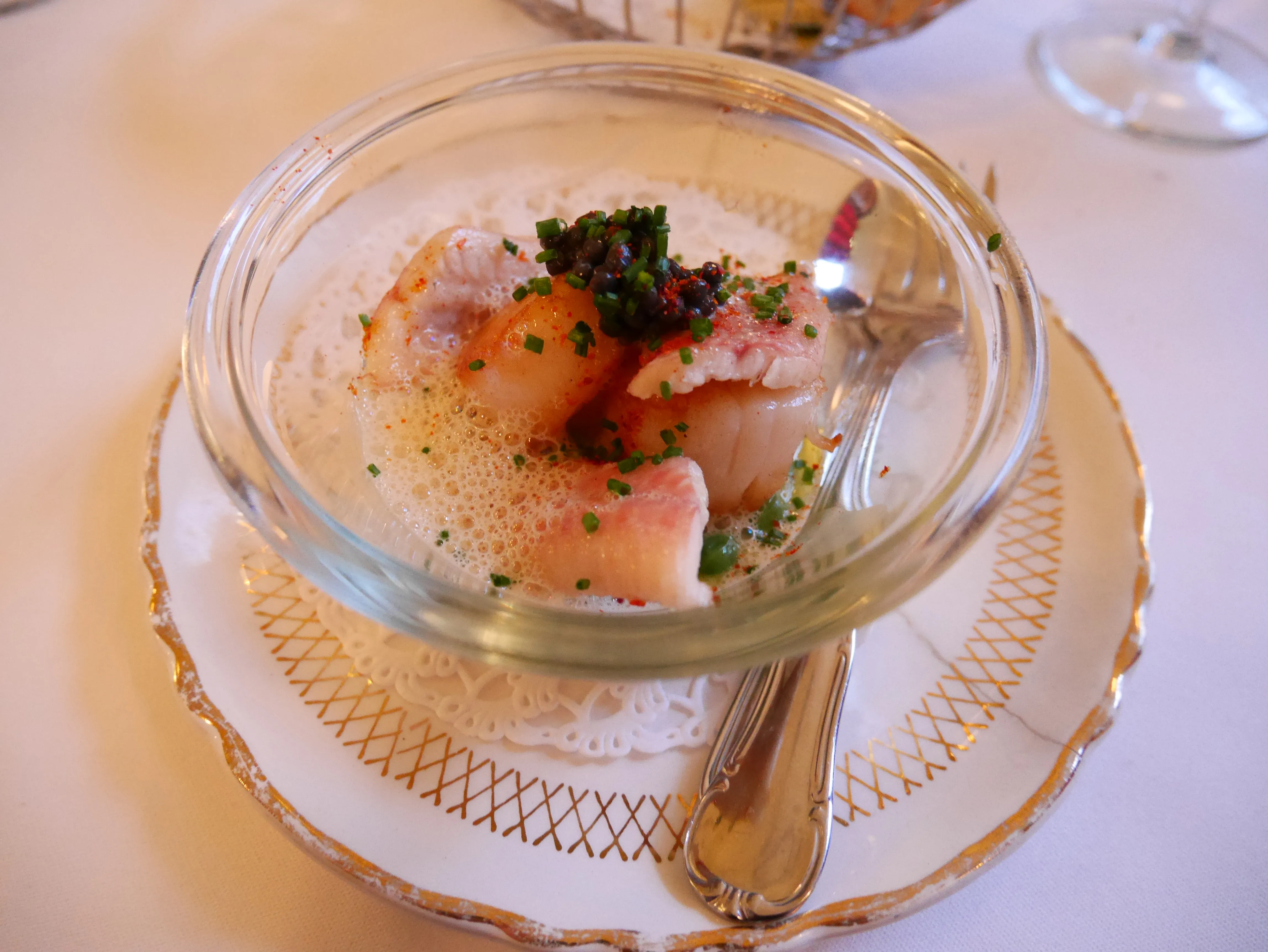 Exquisite Coquilles Saint-Jacques mit frischen Kräutern und feinem Fisch als Vorspeise im Bistrot du Bac Rotterdam.
