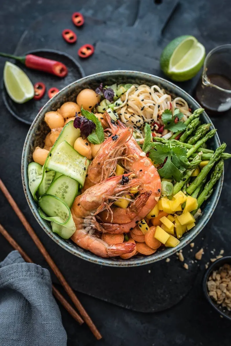 Farbintensive Asia Reisnudel-Bowl mit Garnelen, frischer Mango und knackigem Gemüse, ideal für ein schnelles asiatisches Mittagessen