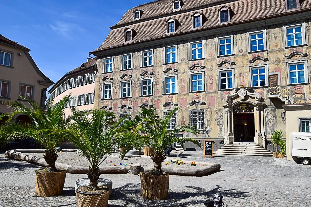 Farbpracht: Bunt bemalte Häuser mit Palmen davor im Cavazzen, Lindau am Bodensee