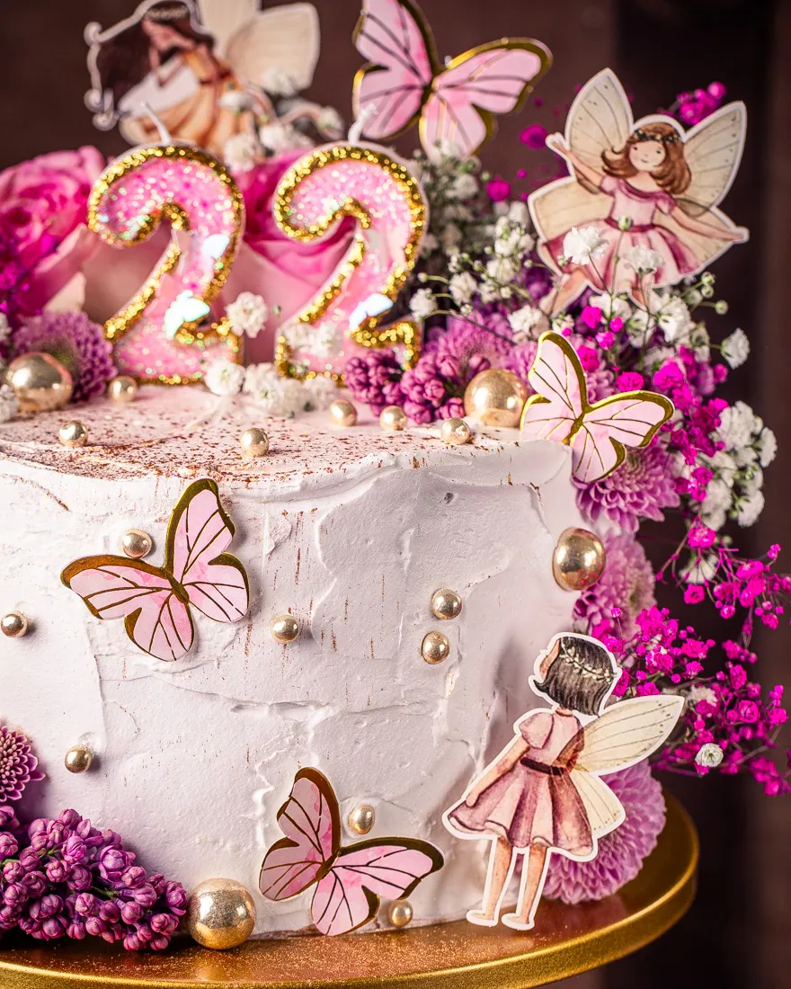 Feenstecker und goldene Schmetterlinge verzieren den Feen Geburtstagskuchen