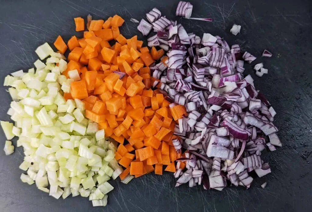 Fein gehacktes Mirepoix aus Karotten, Sellerie und Zwiebeln, Basis der würzigen Shepherd's Pie Füllung