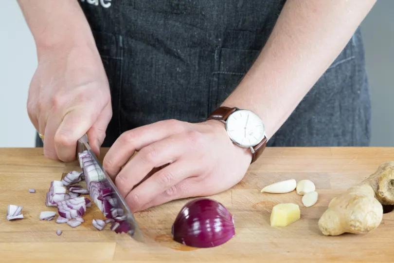 Fein gewürfelte Zwiebeln für eine vegetarische Tajine
