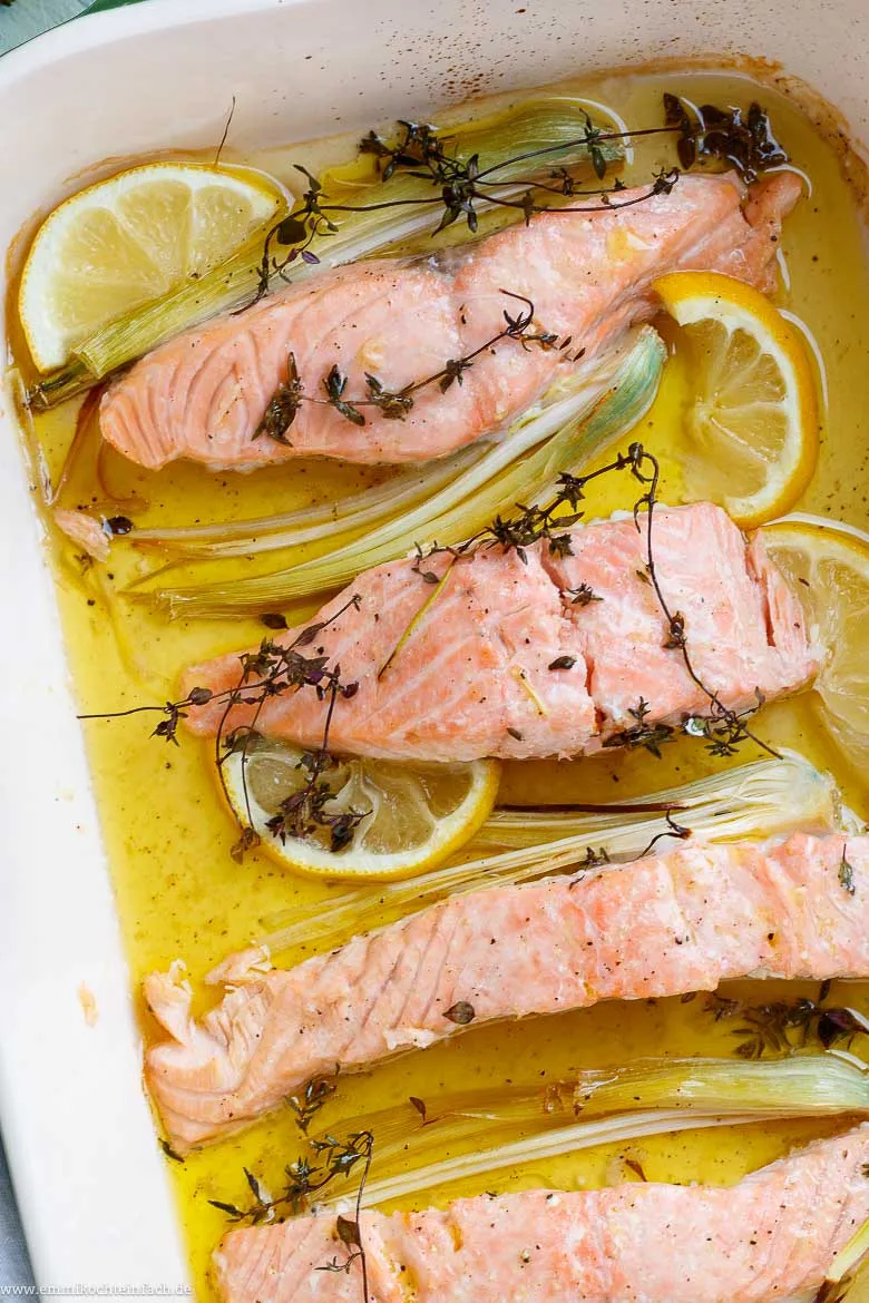 Fertig gebackene Lachsfilets aus dem Ofen, mit Zitrone und mediterranen Kräutern, perfekt für ein schnelles und gesundes Abendessen.