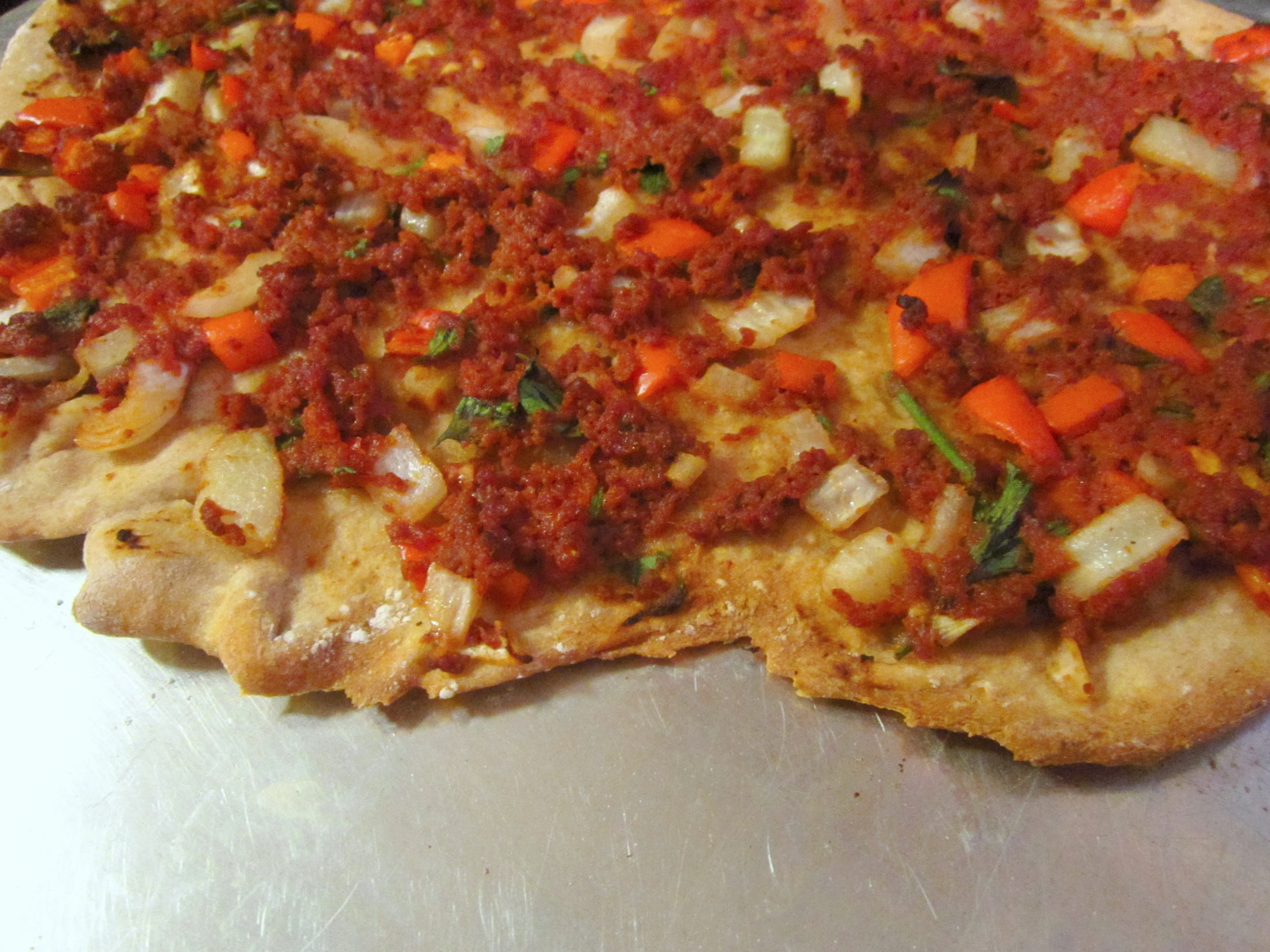 Fertig gebackener Lahmacun mit knusprigem Rand und perfekt gegarter Hackfleischfüllung, ein Genuss für Liebhaber türkischer Küche.