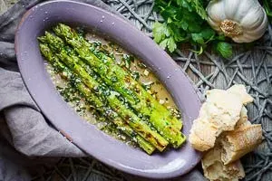 Fertig gebratener grüner Spargel, appetitlich auf einem tiefen Teller angerichtet und servierfertig