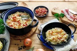 Fertig gekochtes Sauerkraut mit knusprigen Speckwürfeln garniert, bereit zum Servieren als herzhafte deutsche Beilage