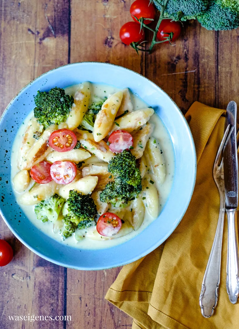 Fertige cremige Schupfnudelpfanne mit Hähnchenbrust und frischen Kirschtomaten, bereit zum Genießen