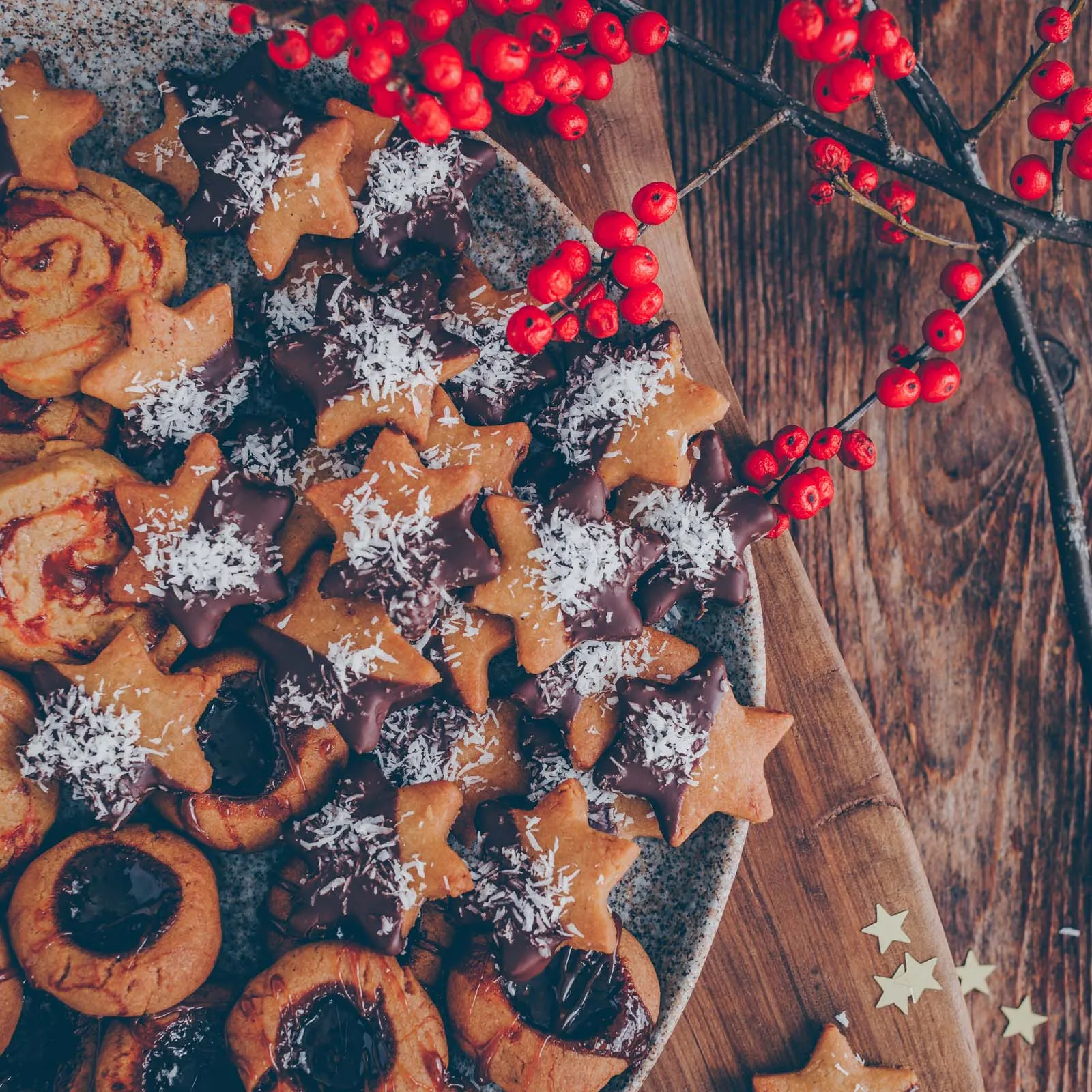 Fertige Kokos-Schoggi-Sterne, kunstvoll halb in Schokolade getaucht und mit Kokosraspeln bestreut, bereit zum Genießen