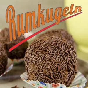 Fertige Rumkugeln aus Kuchenresten mit Schokostreuseln, präsentiert in Papiermanschetten, bereit zum Genuss.