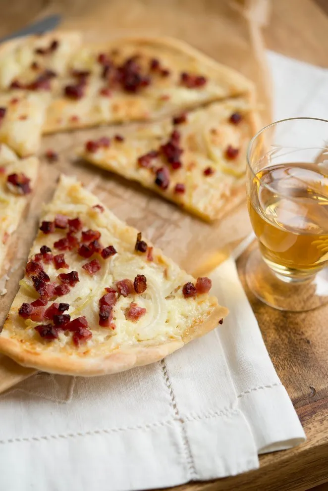 Fertiger, appetitlicher Flammkuchen in Stücke geschnitten, ideal für ein schnelles Abendessen