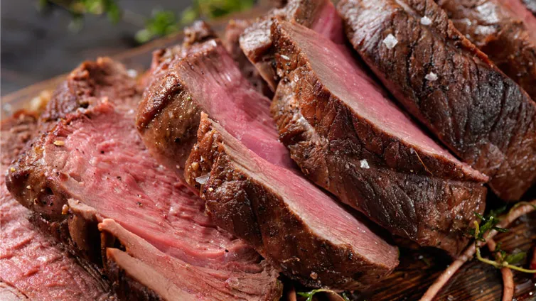 Fertiger Hirschbraten mit Soße und Preiselbeeren auf einem Teller