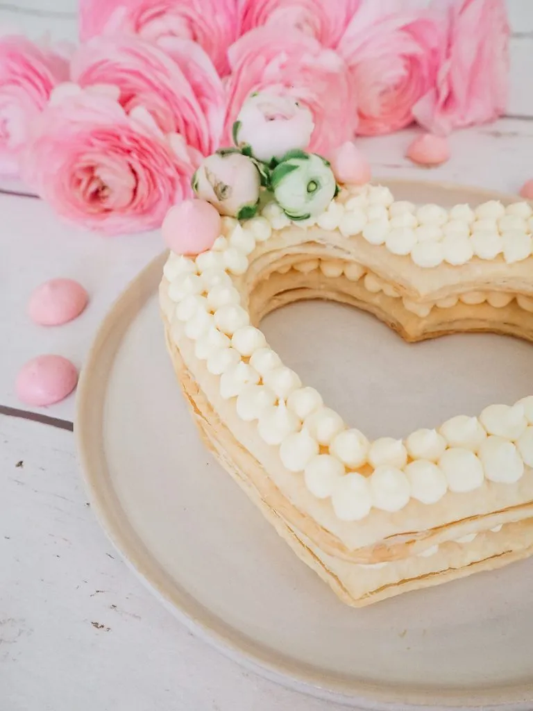 Fertiger Muttertagskuchen in Herzform, dekoriert mit Frischkäse-Tupfen und Beeren