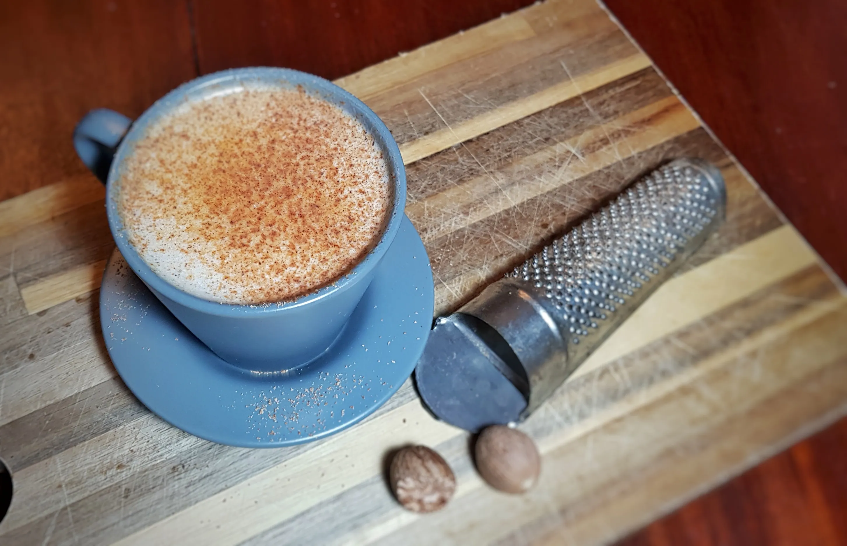 Fertiger Scáiltín Milch-Punch in zwei Tassen, auf einem Holztisch mit festlicher Dekoration, bereit zum Genuss.