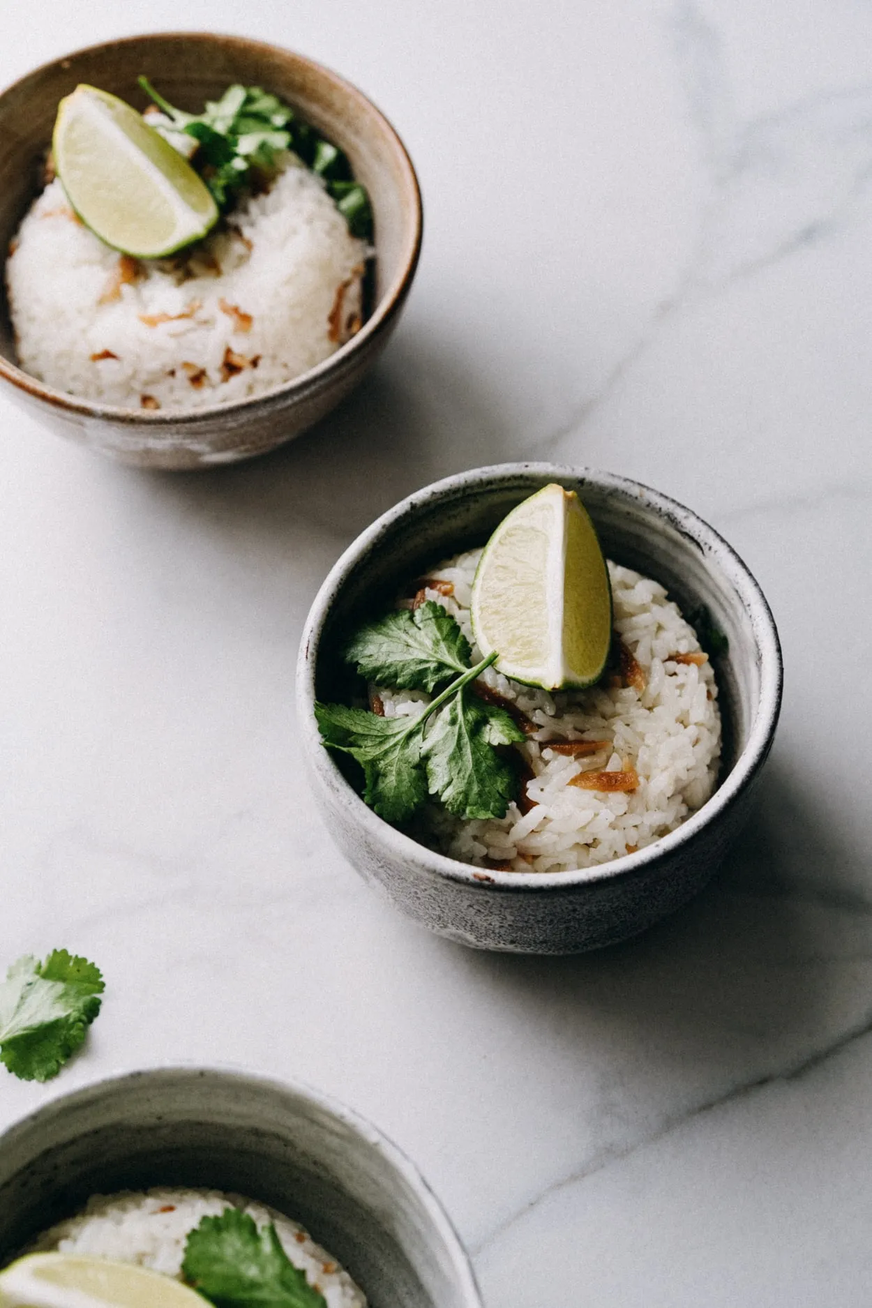 Fertiger türkischer Reis Pilav, angerichtet in Schüsseln und garniert mit frischen Limettenspalten und Koriander.