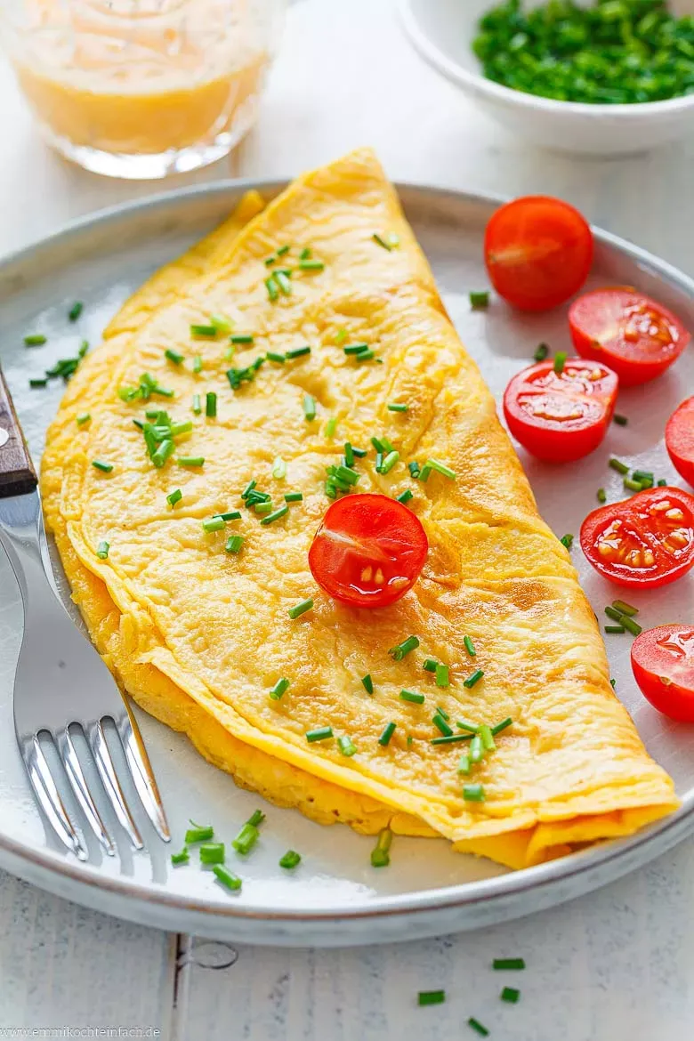 Fertiges, fluffiges Omelett auf einem Teller, servierbereit als schnelles Frühstück oder leichtes Mittagessen.